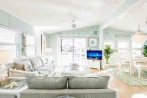 a living room with a couch and a tv at OCEANIA... water front cottage retreat ~ in Cudjoe Key
