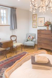 a living room with a bed and a chair and a dresser at The Rear of the Plough,Everdon. in Daventry