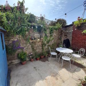 a patio with a table and chairs and plants at The Hideaway in Swanage