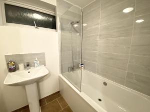 a bathroom with a sink and a shower and a tub at ThePropertyFocus - Stylish Cosy Stay in Manchester