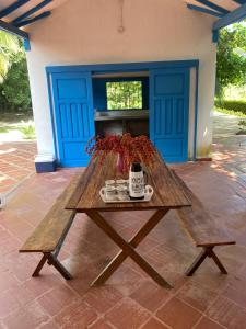 einem Picknicktisch aus Holz mit einer Kaffeetasse darauf in der Unterkunft Finca del Rio Palomino in Palomino