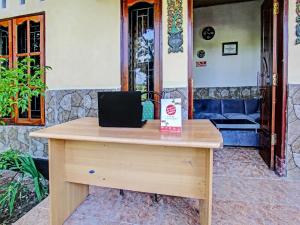 einen Holzschreibtisch mit einem Laptop darüber in der Unterkunft OYO 92059 Archi Homestay in Lembuak