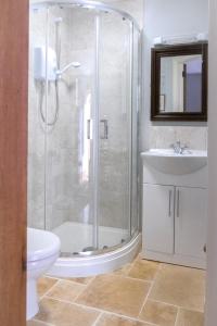 a bathroom with a shower and a toilet and a sink at The Rear of the Plough,Everdon. in Daventry