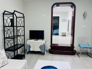 sala de estar con espejo y TV en Apartamento adosado con terraza en Playa América, Nigrán en Nigrán