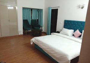 1 dormitorio con 1 cama grande y cabecero azul en Jay Ally - Boutique Hotel, en Nueva Delhi