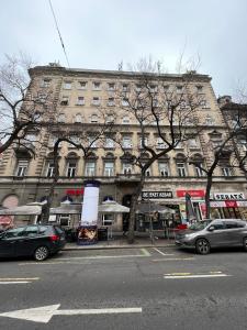 ein großes Gebäude mit davor geparkt in der Unterkunft Luxury Apartment With Balcony next to the New York Café in Budapest