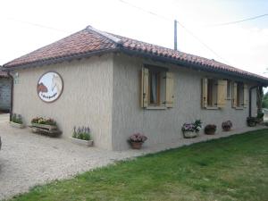 a small house with potted plants in front of it at Gite de la Jument grise-calme et tranquillité in Lescheroux