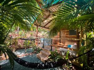 ein Resort mit einer Hängematte inmitten eines Gartens in der Unterkunft Glamping Hotel Flor y Bambu in Playa Grande