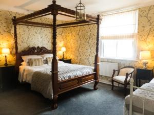 a bedroom with a four poster bed and a window at Ye Olde Smugglers Inne in Alfriston