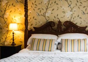a bedroom with a canopy bed with a floral wallpaper at Ye Olde Smugglers Inne in Alfriston