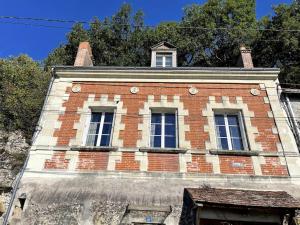 an old brick building with two windows on top at Le Petit Nice Maison semi-troglodyte de charme. in Vouvray