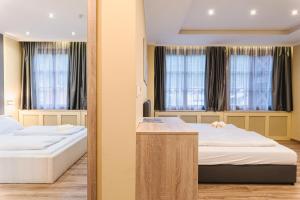 a hotel room with two beds and two windows at VillaJazz Apartments in Murau