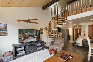 a living room with a tv and a staircase at Tamarron Lodge Loft 316 in Durango