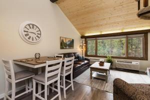 a living room with a table and a clock on the wall at Tamarron Lodge Loft 316 in Durango