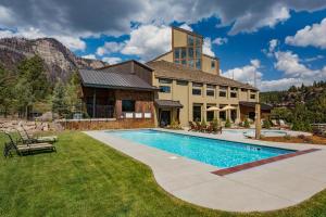 a house with a swimming pool in front of a building at Tamarron Lodge Loft 316 in Durango