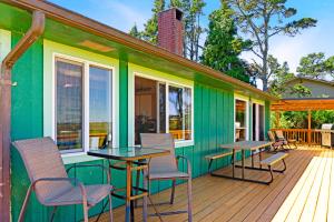 a green house with chairs and tables on a deck at Surfer's Â Landing in Westport