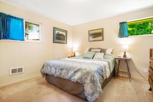 a bedroom with a bed and two windows at Surfer's Â Landing in Westport
