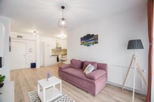 a living room with a purple couch and a table at Duet Noir in Oradea
