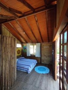 Un dormitorio con una cama en una cabaña de madera. en Casa Sol & Lua, en Florianópolis