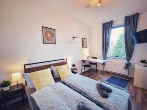 a bedroom with a bed and a desk and a window at Apartments an der Kreuzstraße in Braunschweig