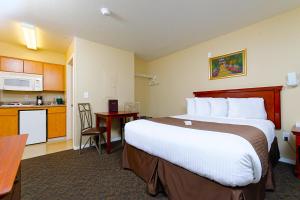 a hotel room with a large bed and a kitchen at Siegel Select Casa Grande in Casa Grande