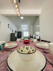 a room with bowls and plates on a table at Homely, Guarded Community, 1km To Commercial Area in Seremban