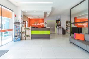 a store lobby with a couch in front of a counter at Hotel Conexão in Penha