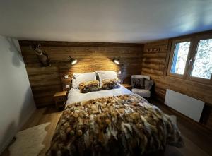 Schlafzimmer mit einem großen Bett und Holzwänden in der Unterkunft Chalet de l'Ours : 4 étoiles-spa-proche des pistes in La Clusaz