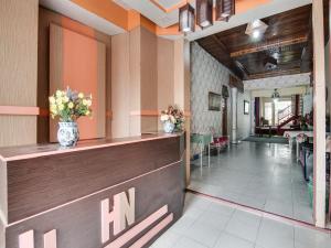a hotel lobby with a reception counter and flowers at OYO 92055 Nirvana Homestay Syariah in Bangkinang