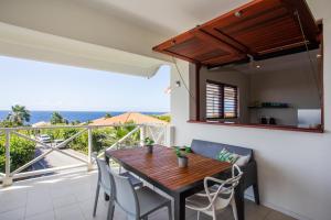een eetkamer met een tafel en stoelen en een balkon bij Boca Gentil sea view apartment - Jan Thiel in Jan Thiel