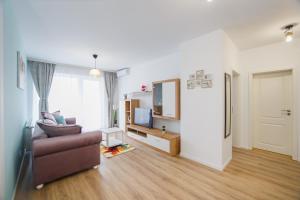 un salon avec un canapé et une télévision dans l'établissement Duet Blanc, à Oradea