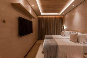 una camera d'albergo con due letti e una televisione di POUSADA DO MIRANTE a Fernando de Noronha