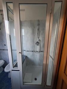 baño con ducha y puerta de cristal en Flatinrome Residence Fiera, en Ponte Galeria