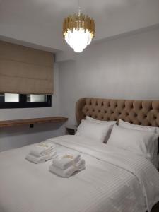 a bedroom with a white bed with two towels on it at October Luxury Apartments Studio in Ioannina