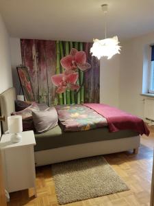 a bedroom with a bed with flowers on the wall at Waldhaus in Neu Drefahl