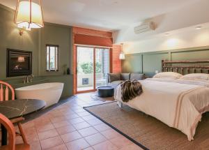 a bedroom with a large bed and a bath tub at Outland Chalet & Suites Great Smoky Mountains in Whittier