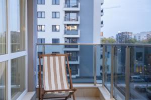 - un fauteuil à bascule sur un balcon avec un bâtiment dans l'établissement Elite Business Residence, by Holiwork Stays, à Plovdiv