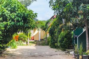 a street in a garden with trees and a building at OYO 92060 We Bro Kost in Kupang