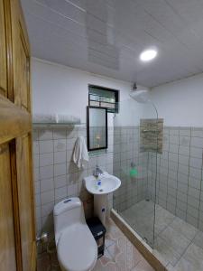 a bathroom with a toilet and a sink and a shower at Private Mountain House With a Pool in Orotina
