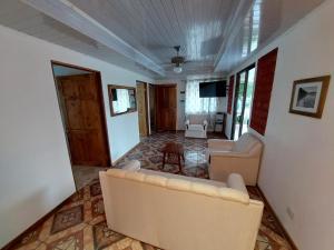 a living room with two couches and a television at Private Mountain House With a Pool in Orotina