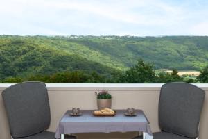 een tafel en stoelen op een balkon met uitzicht bij Studio LAVANDA - Explore Istrian Riviera and Inland in Tinjan
