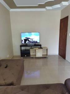 a living room with a couch and a flat screen tv at Apartamento de luxo com 2 quartos, sala com sacada, cozinha área de serviço e 1 banheiro social. in Ipatinga