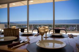 una mesa con platos y vasos sobre una mesa con vistas en Dpto de 2 dorm, en el corazón de la ciudad en San Fernando del Valle de Catamarca