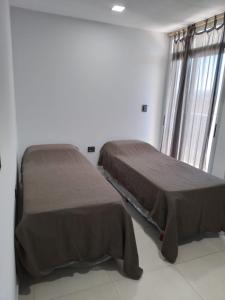 deux lits côte à côte dans une chambre dans l'établissement Dpto de 2 dorm, en el corazón de la ciudad, à San Fernando del Valle de Catamarca