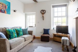 a living room with a couch and a tv at Appleyard Cottage - Yorkshire Dales in Hellifield