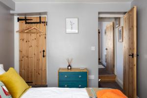 1 dormitorio con 1 cama con armario azul y puerta en Appleyard Cottage - Yorkshire Dales, en Hellifield