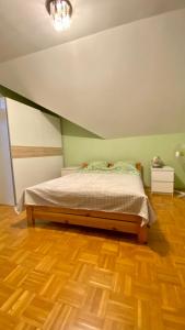 1 dormitorio con 1 cama y suelo de madera en Dorothy en Cracovia