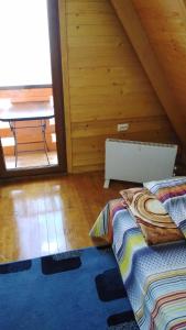 a bedroom with a bed and a table in a attic at ROMANIJA - Brvnara za odmor in Han Pijesak