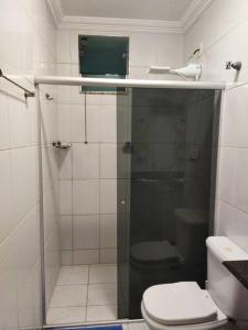 a bathroom with a toilet and a glass shower at Apartamento de luxo com 2 quartos, sala com sacada, cozinha área de serviço e 1 banheiro social. in Ipatinga