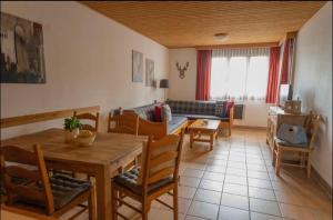 a living room with a wooden table and chairs at Familienapartment Sonne und Schnee in Kanzelhöhe